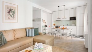 Un apartamento moderno con sala de estar, kitchenette y comedor.