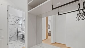 Een modern interieur met een marmeren wand, een witte bank en een houten vloer.