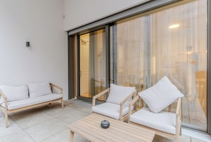 Un salon moderne avec un canapé, deux fauteuils et une petite table.