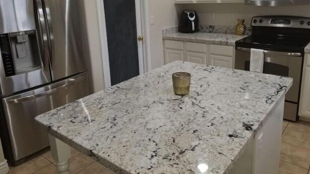 A kitchen with white cabinets, stainless steel appliances, and a granite countertop. - Charming 3-bedroom house in marvelous Phoenix with WiFi, AC (Phoenix)
