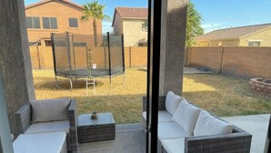 A patio with wicker furniture and a trampoline. - Charming 3-bedroom house in marvelous Phoenix with WiFi, AC (Phoenix)