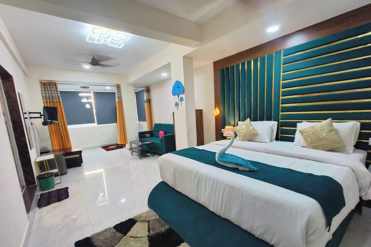 A modern hotel room with two beds, a sofa, a TV, and a large window with curtains.