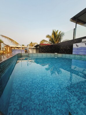 A swimming pool with tiled walls and a clear blue water surface. - Small Daddy Plus (Calangute)