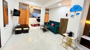 A modern living room with a sofa, coffee table, and a TV mounted on the wall. - Small Daddy Plus (Calangute)