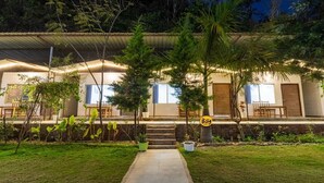 Una casa moderna con un portico coperto, un vialetto che conduce all'ingresso e un giardino curato.