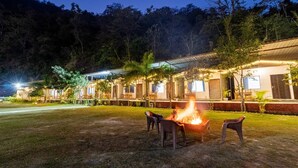 Un hotel con diverse camere, un braciere e posti a sedere all'aperto.