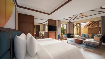 A hotel room with a large bed, a sofa, a television, and a dining area.