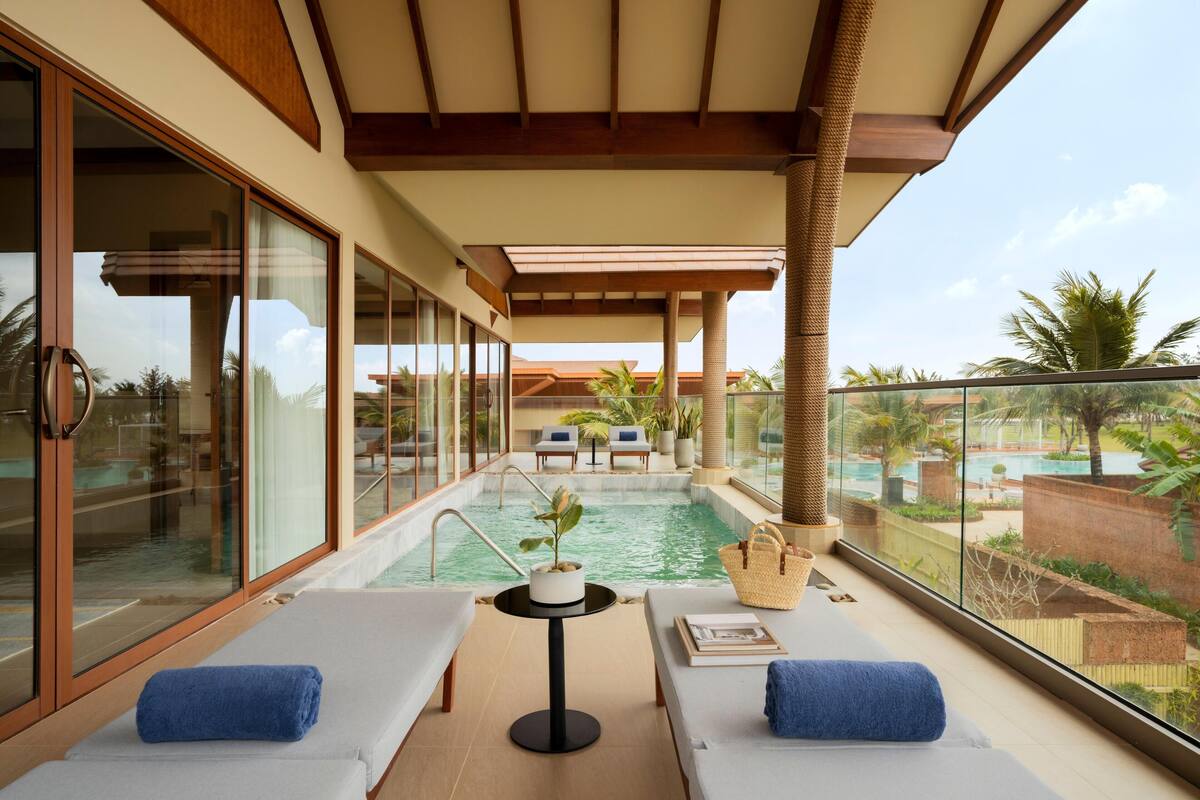 Un balcón con piscina, sillas de descanso y vista al área de la piscina.