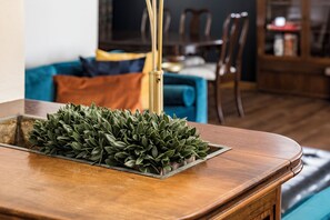 A wooden table with a plant on it, a blue sofa, and a dining area in the background. - Spacious 4-bedroom house, Fenced Yard, Central Denver & Boulder (Denver)