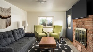 A living room with a sofa, two armchairs, a coffee table, a fireplace, and a large window. - Spacious 4-bedroom house, Fenced Yard, Central Denver & Boulder (Denver)