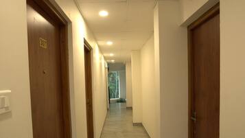 Un couloir avec des portes en bois, numérotées 307, qui donnent accès aux chambres.