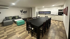Eine moderne Wohnung mit Essbereich, Küchenzeile und Wohnbereich mit Sofa und Hocker.