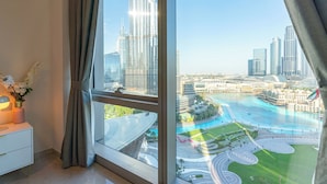 Una moderna camera d'hotel con un'ampia finestra che offre vista su un paesaggio urbano e una passeggiata sul lungomare.