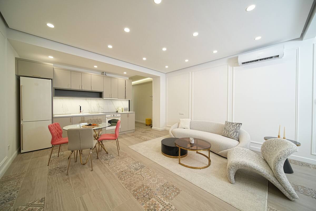 A modern living space with a kitchen, dining area, and seating area.