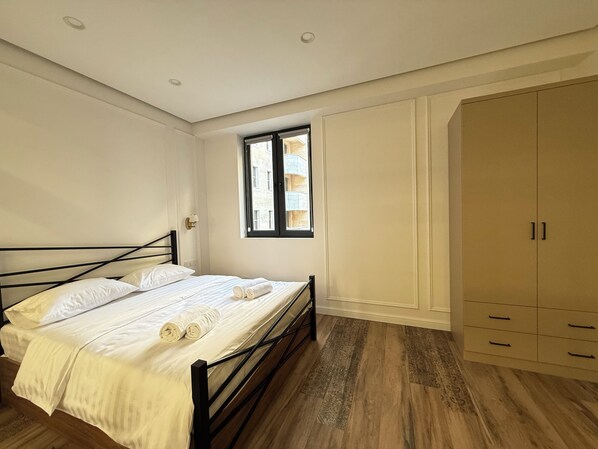 Un dormitorio con cama, ventana y armario.