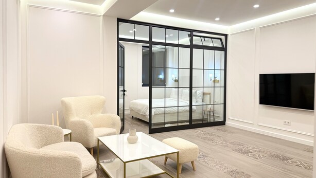A modern bedroom with a large bed, a TV, and a sliding glass door leading to a bathroom. - Sweet Home Prime Apart-Hotel (Yerevan)