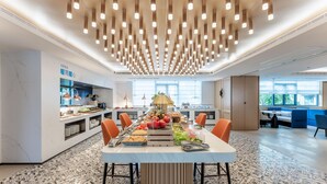 A modern kitchen with a central island, equipped with various appliances and a fruit display. - Holiday Inn Express Haikou World Trade Center (Haikou)
