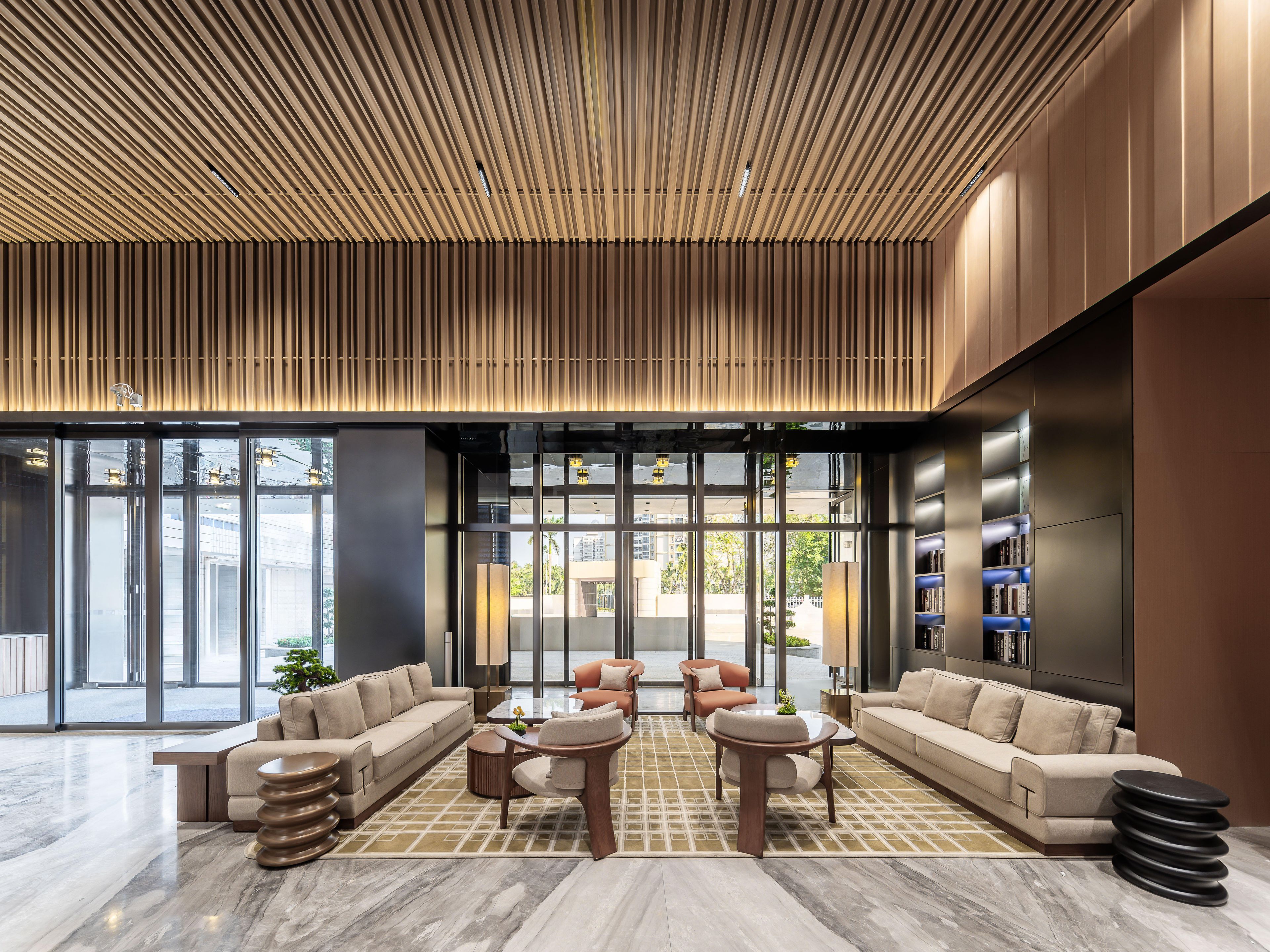 A modern lobby with a sectional sofa, round coffee tables, and a patterned floor.
