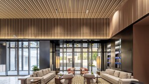 A modern lobby with a sectional sofa, round coffee tables, and a patterned floor. - Holiday Inn Express Haikou World Trade Center (Haikou)