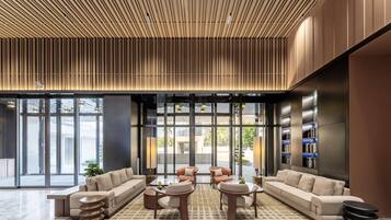 A modern lobby with a sectional sofa, round coffee tables, and a patterned floor.