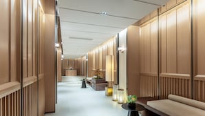 A modern hotel corridor with wooden paneling, a sofa, a small table with a plant, and a bench. - Holiday Inn Express Haikou World Trade Center (Haikou)