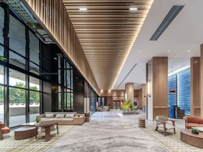 A spacious lobby with a high ceiling, large windows, and modern furnishings. - Holiday Inn Express Haikou World Trade Center (Haikou)