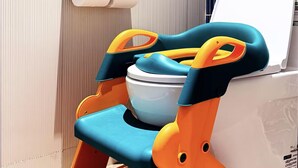 A bathroom with a toilet, a toilet paper holder, and a colorful step stool. - Holiday Inn Express Haikou World Trade Center (Haikou)