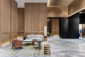A modern lobby with a sectional sofa, a coffee table, and a patterned rug. - Holiday Inn Express Haikou World Trade Center (Haikou)
