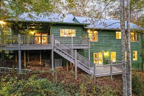A two-story wooden house with a balcony and a staircase leading to the upper level. - Oakey Mountain Hideaway (Clarkesville)