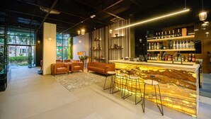 Un área de bar moderna con una encimera de mármol, taburetes y una variedad de botellas de licor.