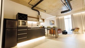 Una cocina moderna con microondas integrado, refrigerador de acero inoxidable y una isla central con pileta.