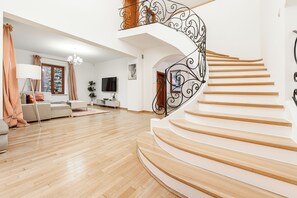 Un vaste espace de vie agrémenté d’un escalier en bois et doté d’un aménagement intérieur moderne.