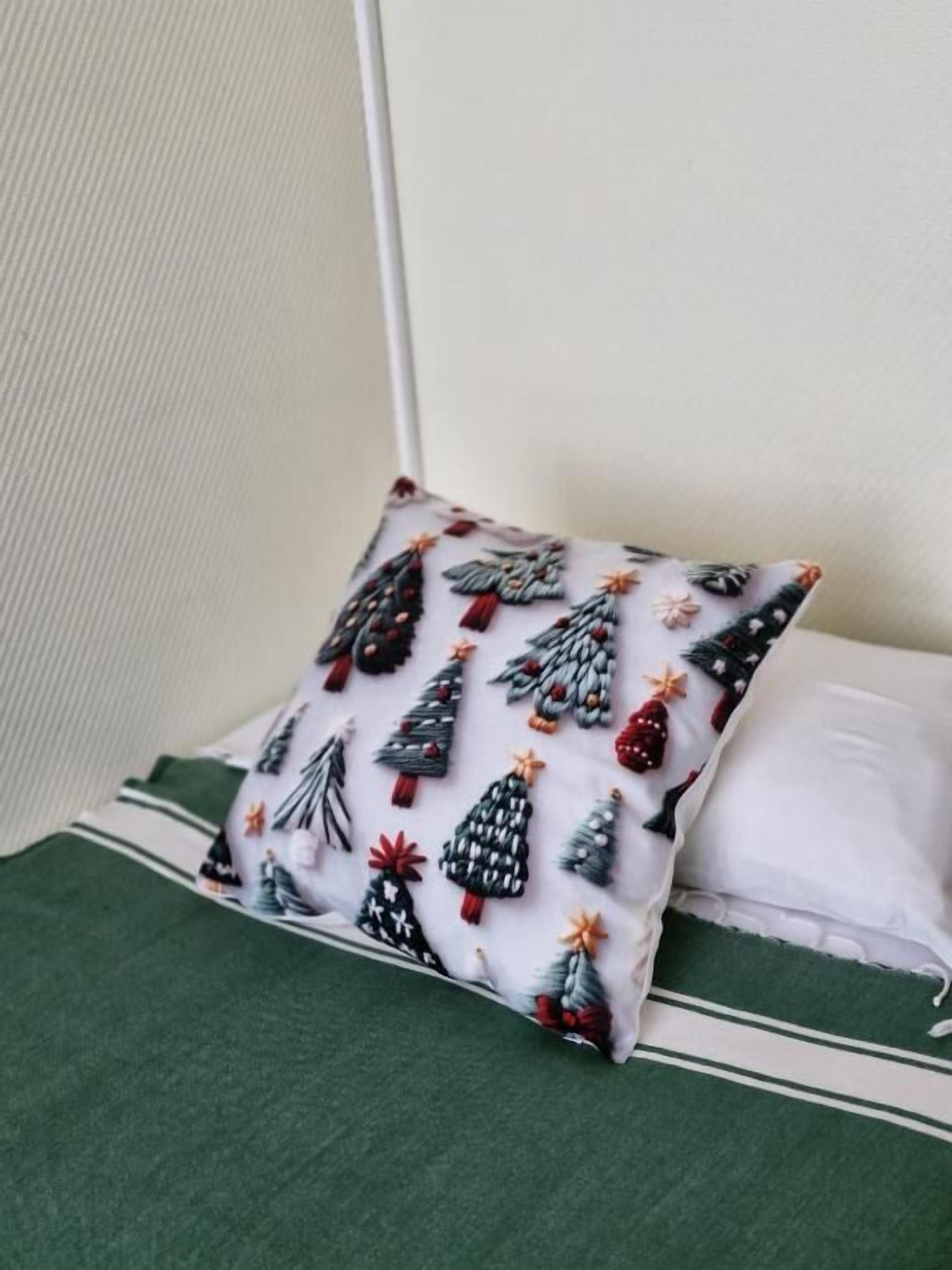 A pillow with a Christmas tree pattern on a bed with a green cover.