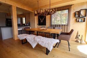A wooden interior with a dining table, benches, and a chandelier. - Superior Chalet # 25 with Sauna (Turrach)