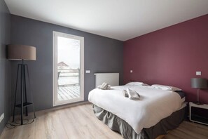 A bedroom with a bed, a floor lamp, a radiator, and a window.