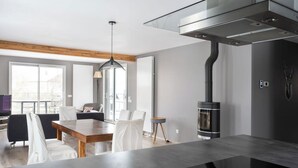Una cocina moderna con una isla central, estufa integrada y comedor con sillas y mesa.