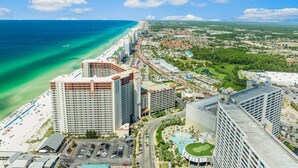 A high-rise hotel with multiple floors, a beachside location, and a view of the ocean.