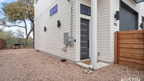 Una casa amb una porta grisa, una bústia i una tanca de fusta.