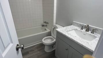 Un baño con inodoro, lavamanos y bañera.