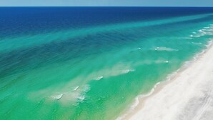 An aerial view of a beach with clear turquoise waters and a sandy shoreline. - Carnoustie Sandestin Bayfront Condo Golf Cart (Miramar Beach)