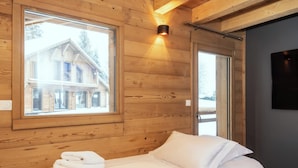 A wooden-paneled room with a bed, a window, and a wall-mounted light fixture. - Chalet Elixir - 14 guests - Pool & Sauna, Gérardmer (Gérardmer)