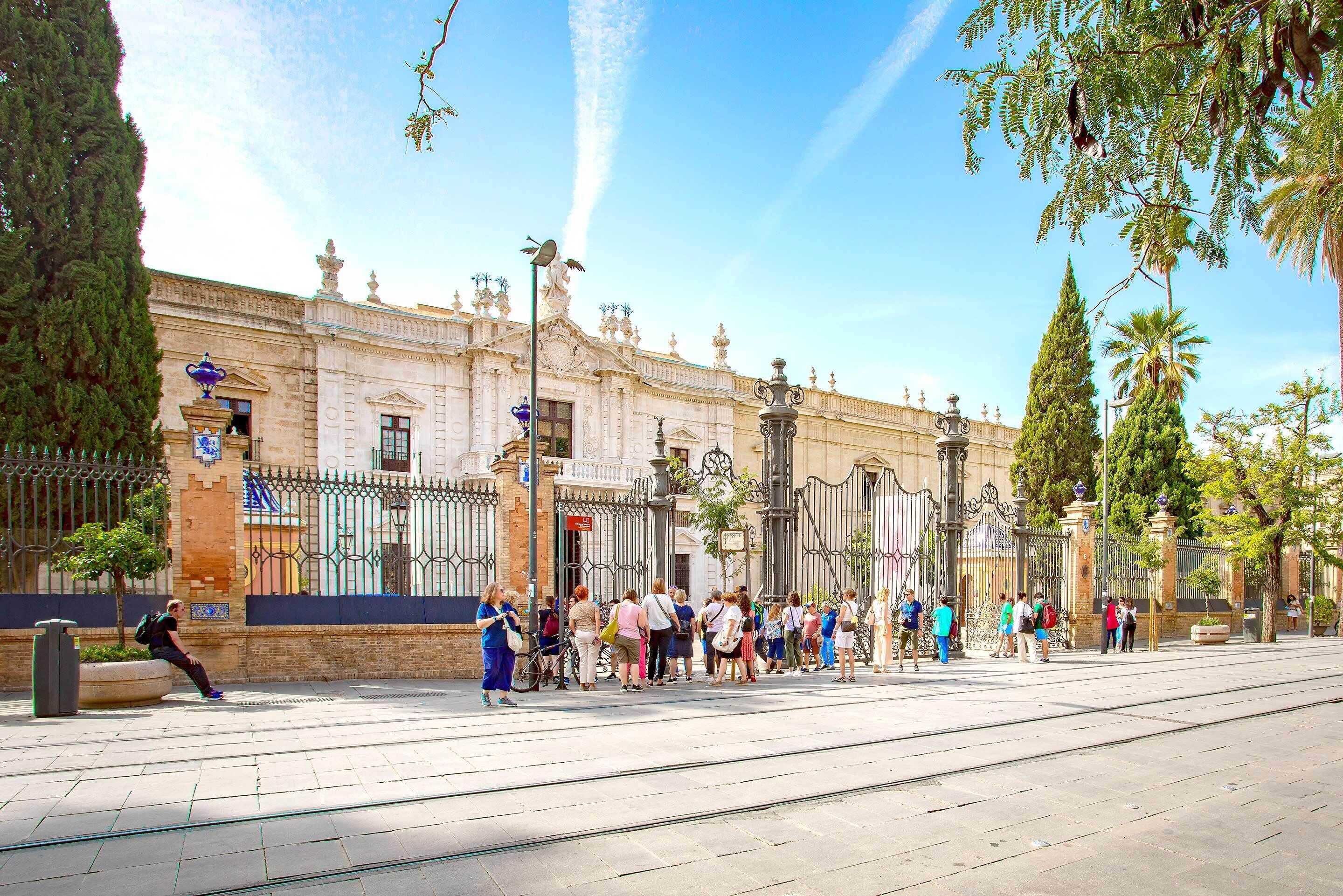 A historic building with a grand facade, a gated entrance, and a clear sky.