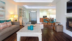 A modern living room with a sofa, coffee table, and dining area. - Genteel Home Venalmar Terrace (Estepona)