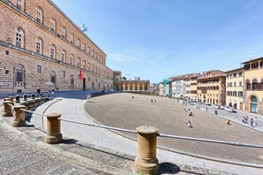 A large open plaza with historic buildings, a prominent clock tower, and a stone balustrade. - Genteel Home Piazza Pitti (Florence)