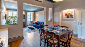 A dining area with a wooden table set for four, surrounded by wooden chairs. - Genteel Home Piazza Pitti (Florence)