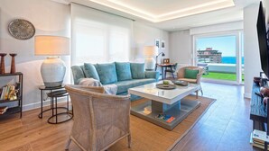 Una sala de estar moderna con sofá, mesa de centro y silla de mimbre. Se ve una estantería y un televisor al lado derecho.