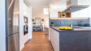 Una cocina moderna con electrodomésticos de acero inoxidable, una isla central y vistas al área de comedor.