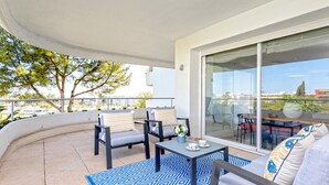 A balcony with outdoor seating, a table, and a view of the city. - Genteel Home Los Flamencos Terrace (Marbella)