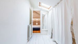 A narrow hallway with white wooden flooring, white curtains, and a skylight. - Genteel Home Scarlatti (Florence)