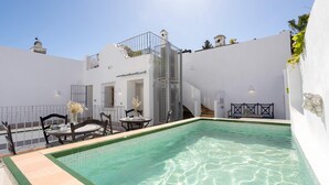 A rooftop pool area with a clear blue pool, a staircase, and outdoor seating. - Genteel Home Pimienta (Seville)